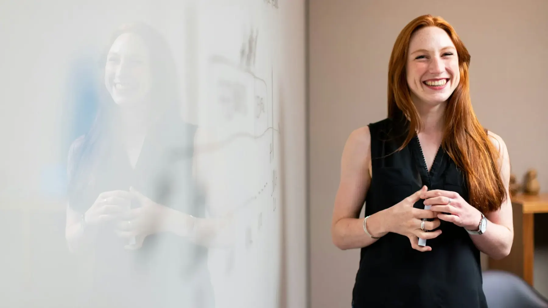 A facilitator presenting at a whiteboard to a seated group